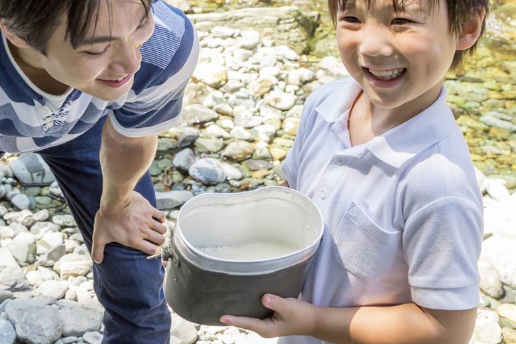 川で水をくむ子どもたち